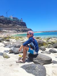 Woman on beach against clear blue sky