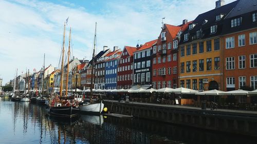 Boats on river by buildings in city