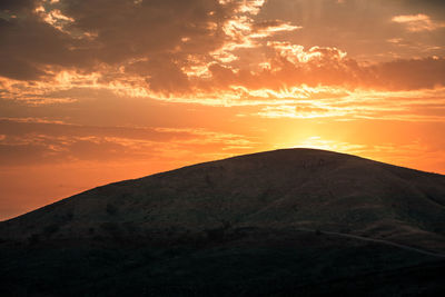 Scenic view of silhouette mountains against sky during sunset