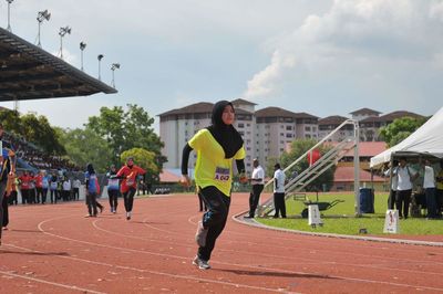 Woman running on sports track during competition