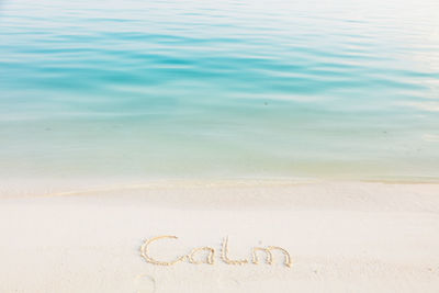 High angle view of text on sand at beach