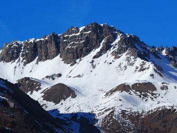 Scenic view of snowcapped mountains against clear blue sky