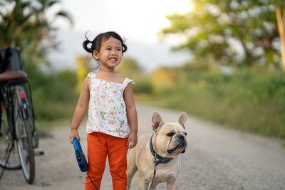Cute girl with dog on dirt road