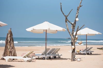 Panoramic view of parasols on beach against clear sky