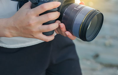 Midsection of woman photographing camera