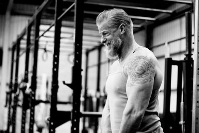 Side view of mature man standing in gym