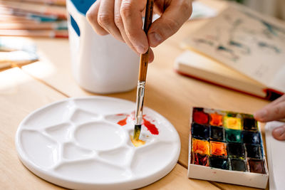 Artist paints with watercolors in a notebook. craft concept. the artist in action.close-up