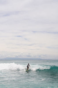 Man surfing on sea against sky