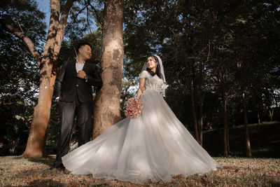 Rear view of bride standing in park