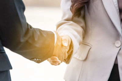 Midsection of couple holding hands