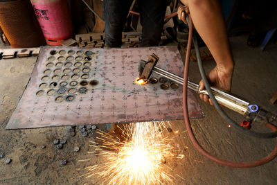 Low angle view of man working on metal