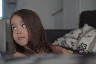 Portrait of cute girl looking away at home