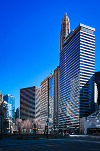 Modern buildings in city against clear blue sky