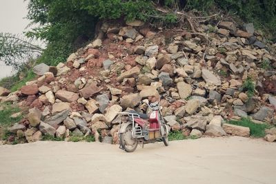 Man sitting on rock by wall