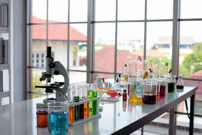 Bottles on table seen through glass window