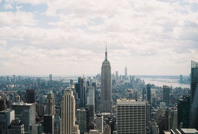 Buildings in city against cloudy sky