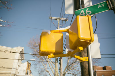 Low angle view of yellow road sign against sky