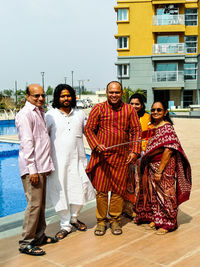 Portrait of people standing at poolside in city