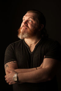 Portrait of man wearing hat against black background