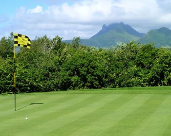 Flag and golf course against sky