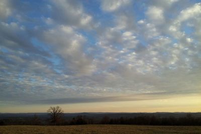 Scenic view of field against cloudy sky