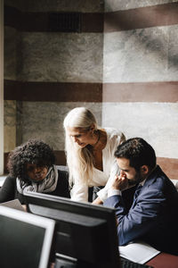 Mature businesswoman discussing with colleagues at law office