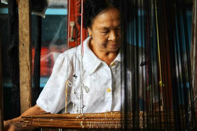 Grandma weaves cloth, seen in the provinces of thailand.