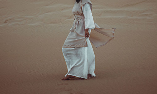 Rear view of woman standing on beach