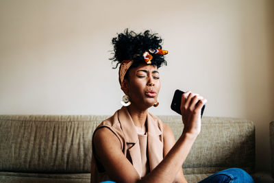 Portrait of teenage girl sitting on sofa at home