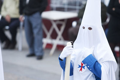 Person wearing traditional clothing in city during parade