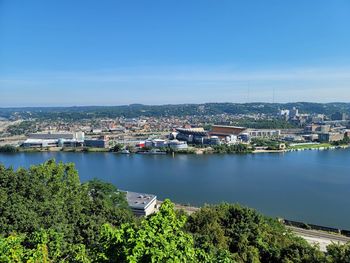 Townscape by sea against clear blue sky