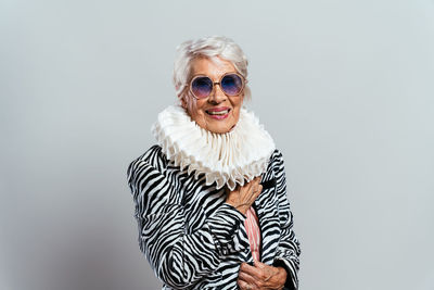 Portrait of young woman wearing sunglasses against white background