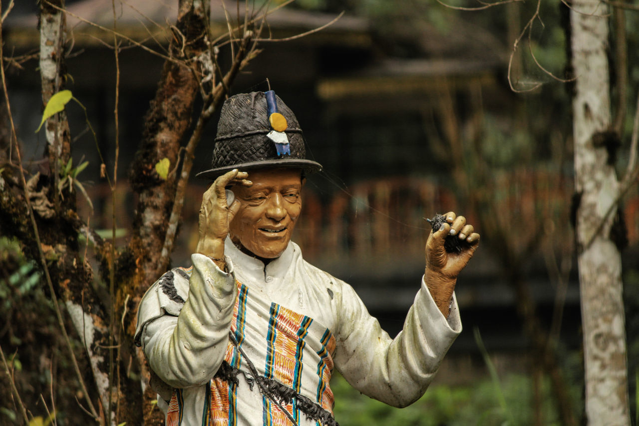 PORTRAIT OF SMILING YOUNG MAN STANDING OUTDOORS