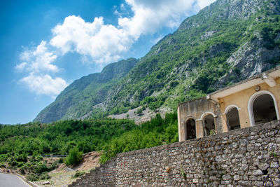 Built structure by mountain against sky