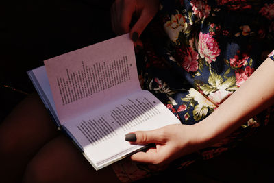 Midsection of woman reading book