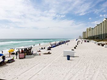 Panoramic view of people on beach against sky