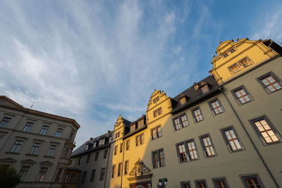 Low angle view of buildings in town against sky