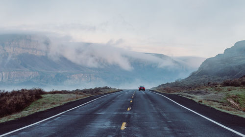 Road amidst mountains against sky