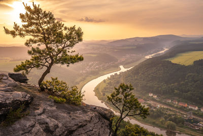 Scenic view of tree mountains against sky during sunset