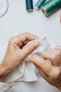 Cropped hand of tailor sewing clothe