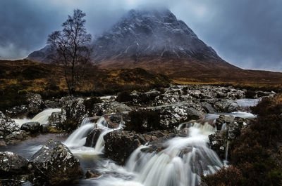 Scenic view of waterfall against sky