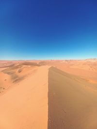 Scenic view of desert against clear blue sky