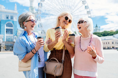 Smiling female friends using phone