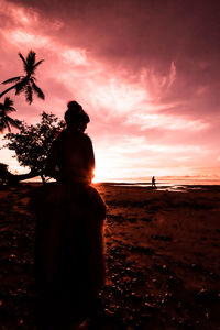 Silhouette man standing by tree against sky during sunset