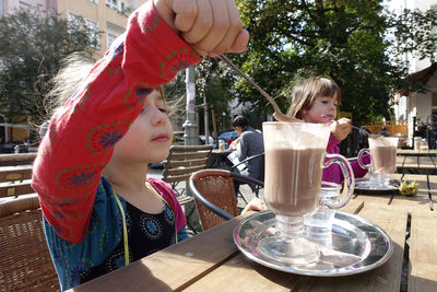 Girl holding ice cream on table