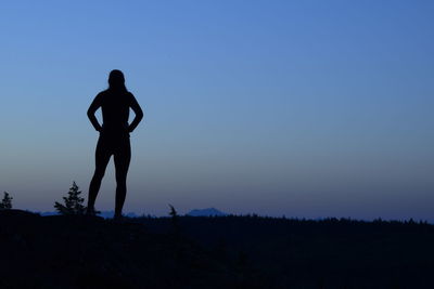 Silhouette man standing against clear sky during sunset