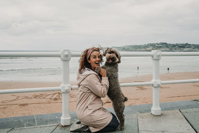 Portrait of woman standing by railing against sea