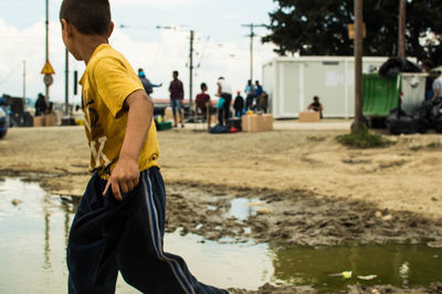 Boy by puddle on street