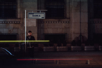 Woman standing on illuminated sign at night