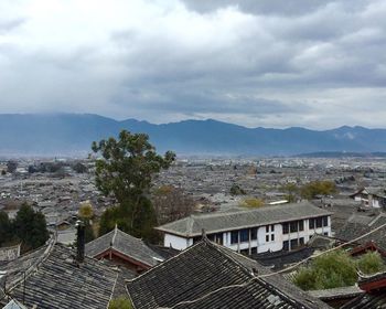 High angle view of houses in city against storm clouds